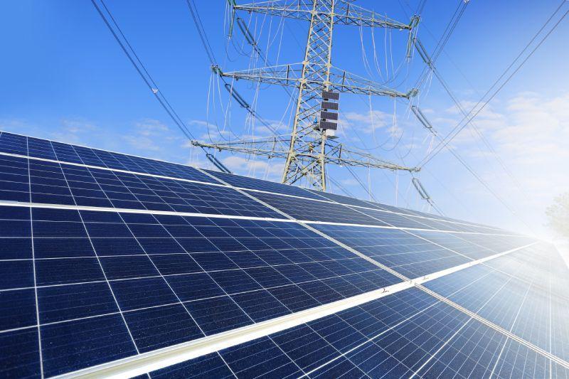 Panele fotowoltaiczne w tle słup energetyczny